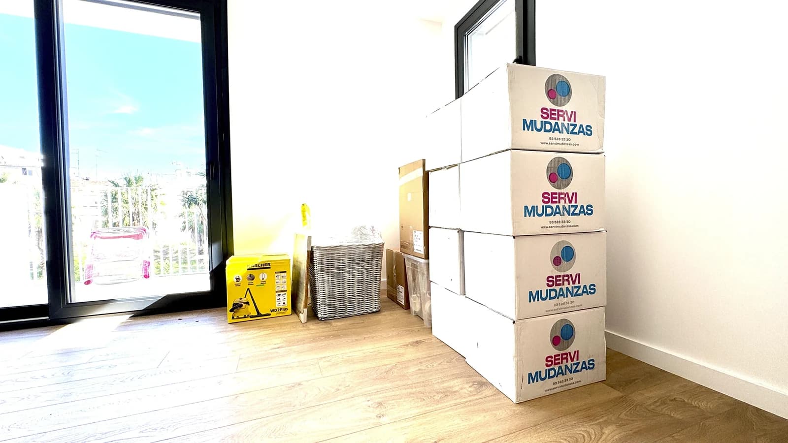 Cajas marca Servimudanzas apiladas en piso vacío listas para mudanza