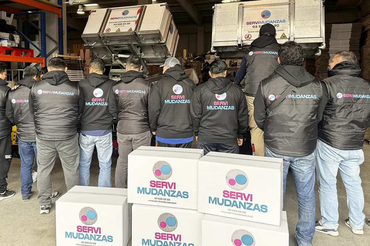 Equipo de operarios de Servimudanzas en plantilla propia con sudaderas corporativas en el almacén