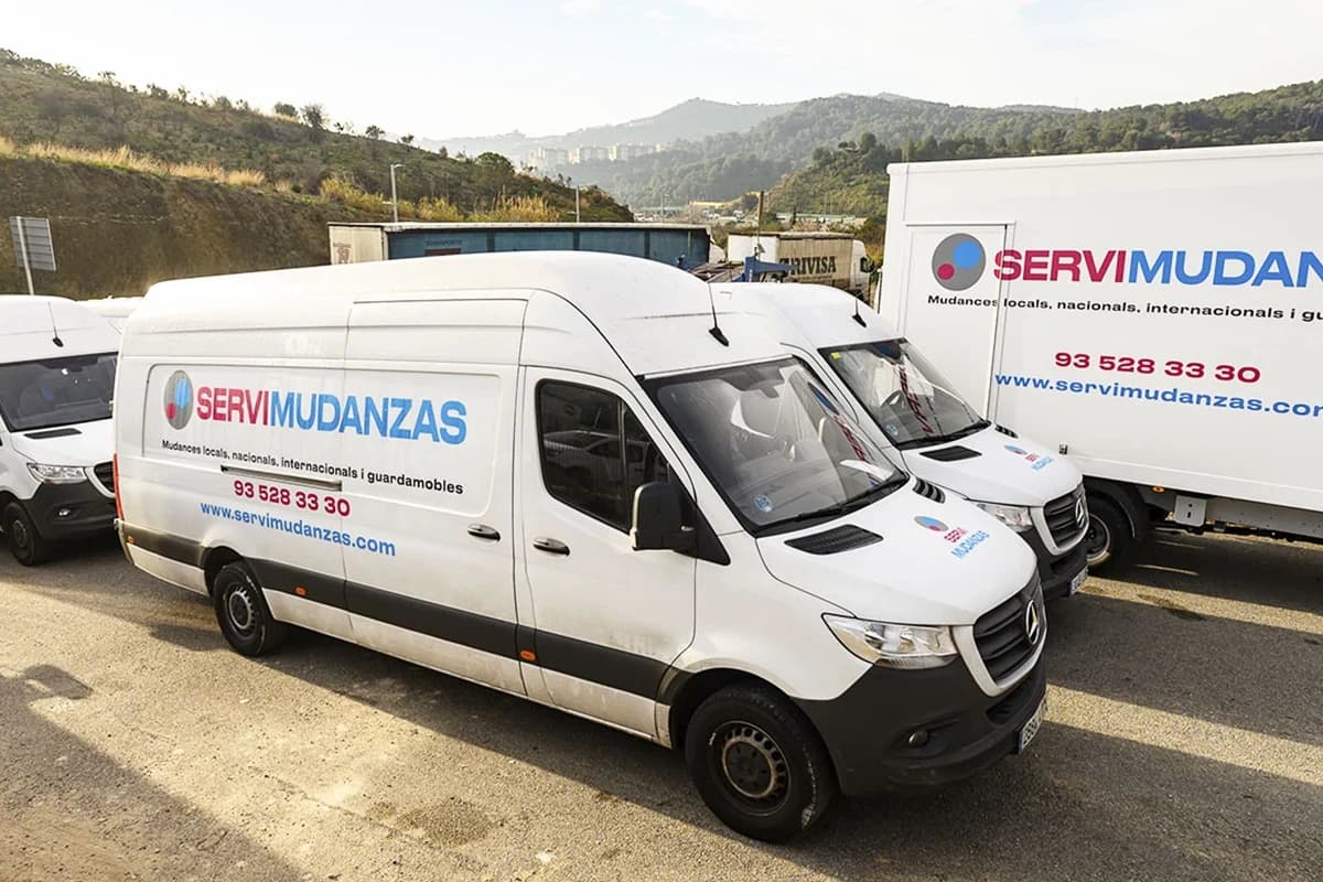 Vehículos de la flota Servimudanzas con marca corporativa visible