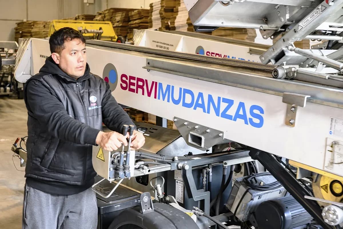 Operario certificado de Servimudanzas operando plataforma elevadora para traslado especial