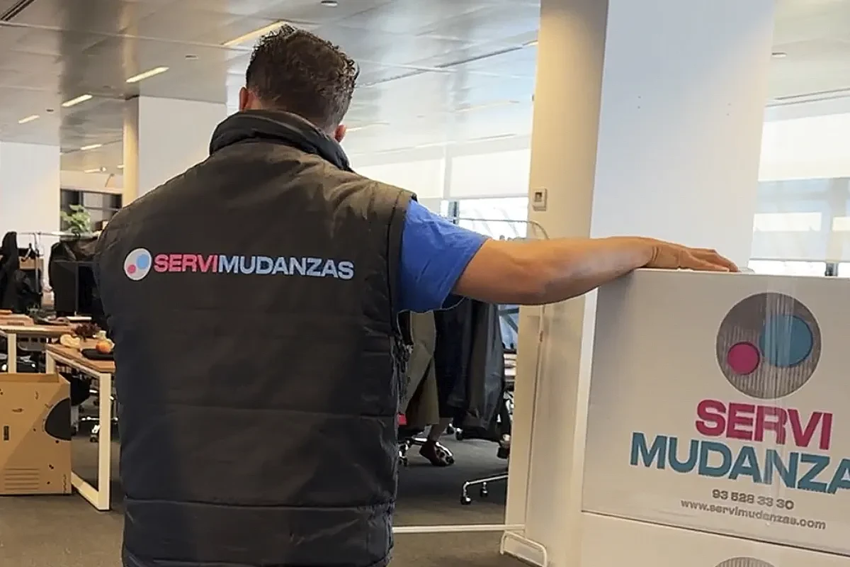 Operario de Servimudanzas con caja preparando un embalaje en mudanza de oficina