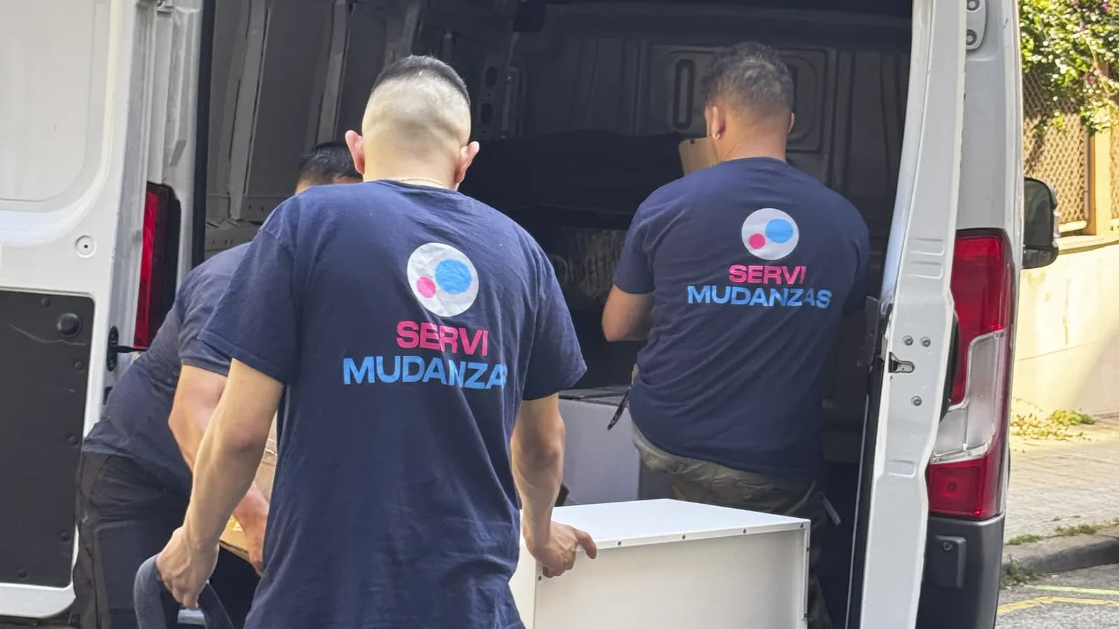 Operarios de Servimudanzas con uniforme de plantilla cargando una furgoneta