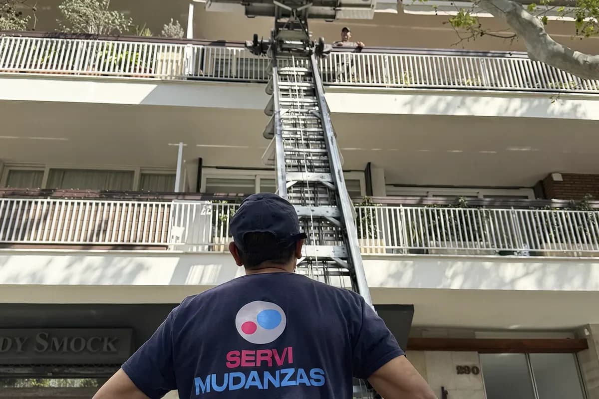 Plataforma elevadora Servimudanzas extendida en avenida con árboles de Barcelona