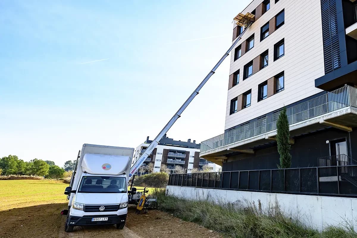 Plataforma elevadora de Servimudanzas desplegada hasta piso alto en mudanza